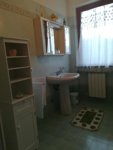a bathroom with a sink and a mirror and a window at GIARDINO DI PRIMAVERA in Bagnoregio