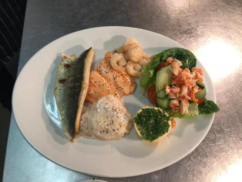 a plate of food with shrimp and vegetables on a table at The Kings Head in New Buckenham