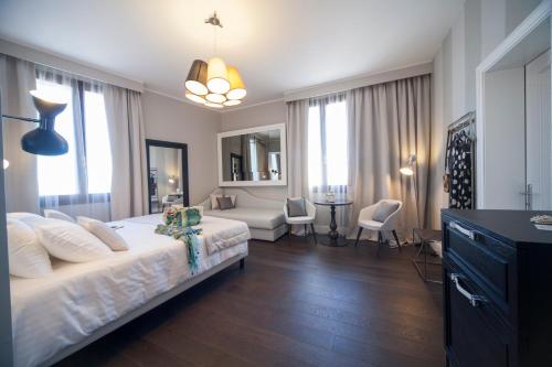 a bedroom with a large bed and a living room at Hotel Grande Italia in Chioggia