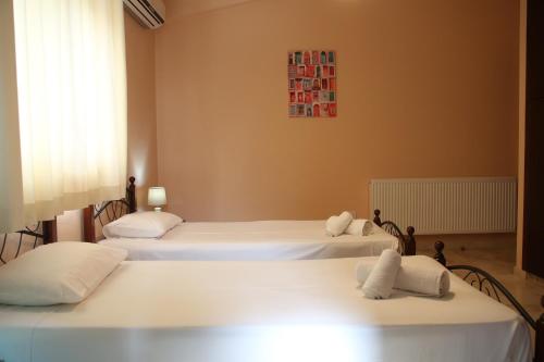 a bedroom with three beds with white sheets at Starlit Villa in Kathikas
