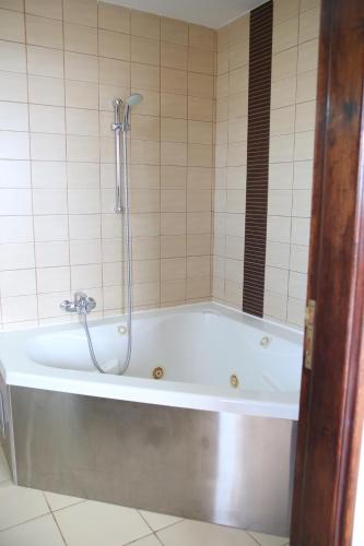 a bath tub with a shower in a bathroom at Starlit Villa in Kathikas