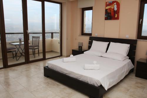 a bedroom with a bed and a balcony with a table at Starlit Villa in Kathikas