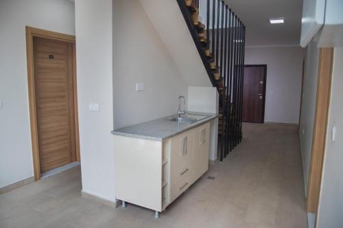 a kitchen with a sink next to a staircase at Troy Lodge in Lusaka