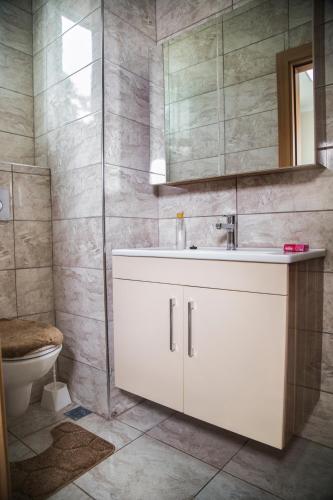 a bathroom with a white sink and a toilet at Troy Lodge in Lusaka