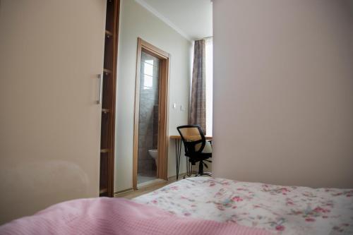 a bedroom with a bed and a chair and a window at Troy Lodge in Lusaka