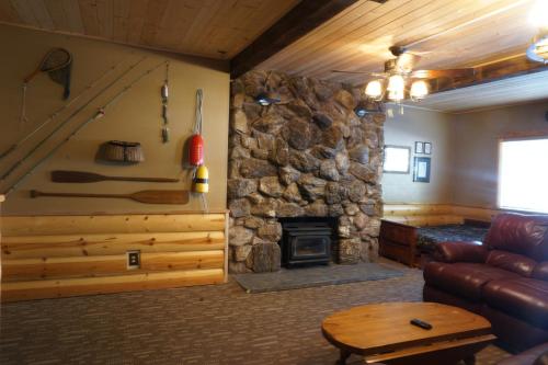 a living room with a stone fireplace and a couch at Shaver Lake Village Hotel in Shaver Lake