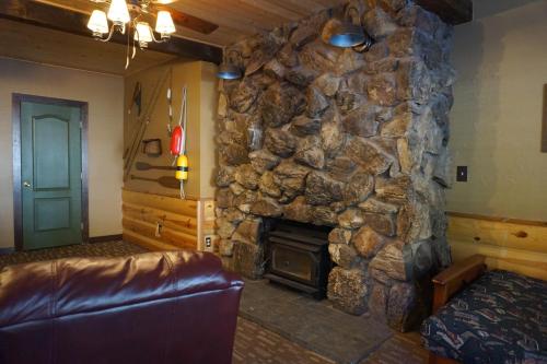 a living room with a stone fireplace and a couch at Shaver Lake Village Hotel in Shaver Lake