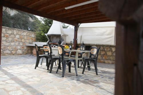 a dining table and chairs on a patio at Starlit Villa in Kathikas