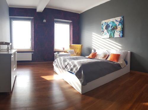 a bedroom with a bed and two windows at TRZY SOWY prywatne pokoje 24h wygodnelokumpl in Bytom