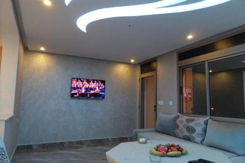 sala de estar con sofá y TV en la pared en Studio deluxe in Agadir en Agadir