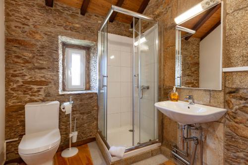 een badkamer met een douche, een toilet en een wastafel bij Loft Caminha in Caminha
