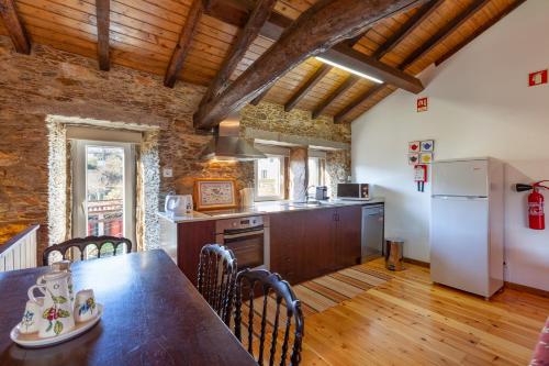 a kitchen with a table and a refrigerator at Loft Caminha in Caminha