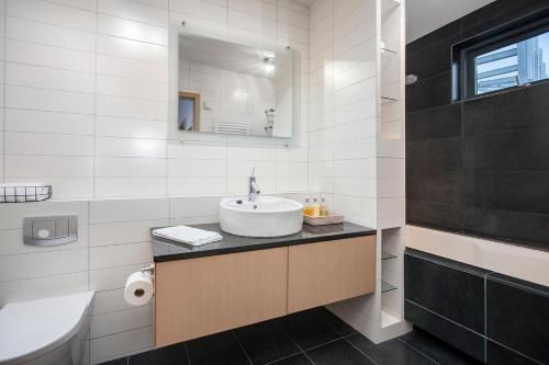 a white bathroom with a sink and a mirror at Planet Apartments in Reykjavík