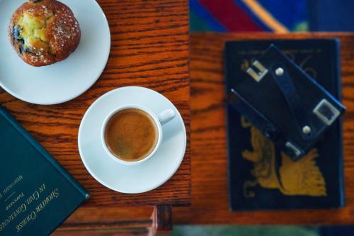 Graduate by Hilton Madison في ماديسون: كوب من القهوة وكعك على طاولة