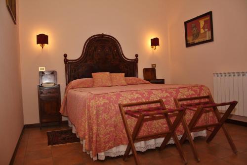 1 dormitorio con 1 cama grande y 2 sillas en Locanda Salimbeni, en San Severino Marche