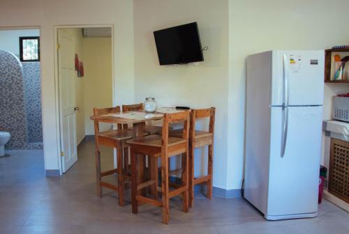a kitchen with a table and a refrigerator at Casa Nelly Apartamentos in Sámara