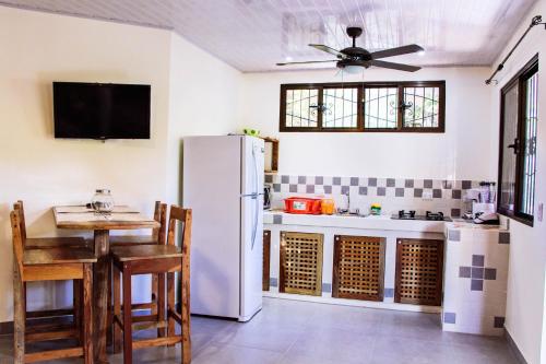 a kitchen with a white refrigerator and a table at Casa Nelly Apartamentos in Sámara