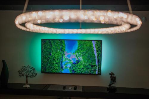 a large snake chandelier in a room with a television at Apartment PLAZA -Wallbox 11kW- Private SPA- Jacuzzi, Infrared Sauna, Luxury massage chair, Parking, Entry with PIN 0 - 24h, FREE CANCELLATION 24 hours before Check In,Premium pillows and mattress in Slavonski Brod