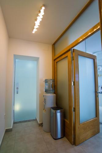 an office room with a door and a trash can at Apartment PLAZA -Wallbox 11kW- Private SPA- Jacuzzi, Infrared Sauna, Luxury massage chair, Parking, Entry with PIN 0 - 24h, FREE CANCELLATION 24 hours before Check In,Premium pillows and mattress in Slavonski Brod