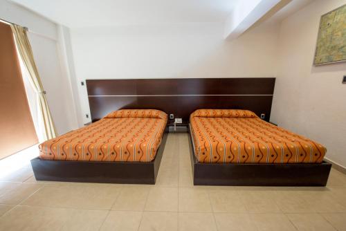 Ένα ή περισσότερα κρεβάτια σε δωμάτιο στο Hotel Oaxaca Inn Express