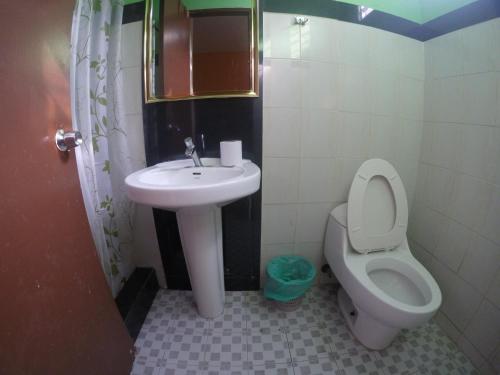 a bathroom with a toilet and a sink at Hotel Villa del Mar in Panama City