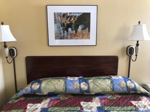 a bedroom with a bed with two lamps at Baxter Park Inn in Millinocket