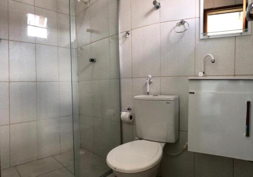 y baño con aseo y ducha acristalada. en Pousada Cruzeiro do Sul, en São Miguel do Gostoso