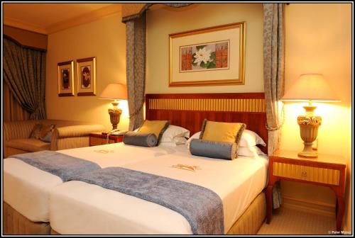a hotel room with a large bed and a couch at Peermont D'oreale Grande at Emperors Palace in Kempton Park