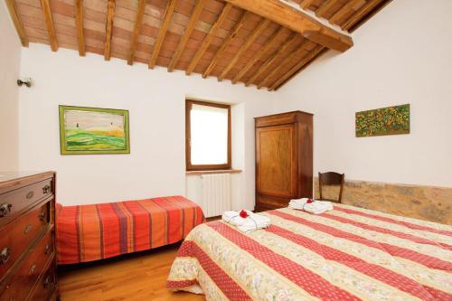 a bedroom with two beds and a window at Podere Il Tigliolo in Castiglione dʼOrcia