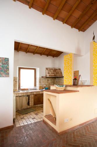 a large kitchen with a counter and a window at Podere Il Tigliolo in Castiglione dʼOrcia