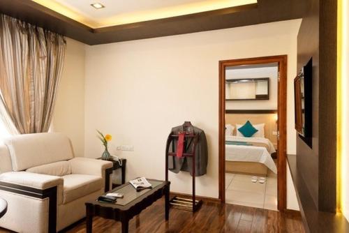 a living room with a couch and a bedroom at Hotel Southern Grand in Vijayawāda