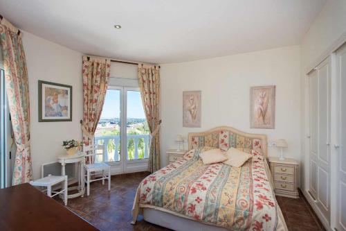 a bedroom with a bed and a table and a window at CH Villa Jupiter La Marquesa in Rojales