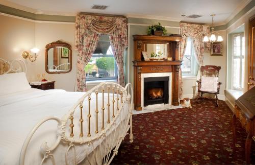 ein Schlafzimmer mit einem Bett und einem Kamin in der Unterkunft Doryman's Oceanfront Inn in Newport Beach