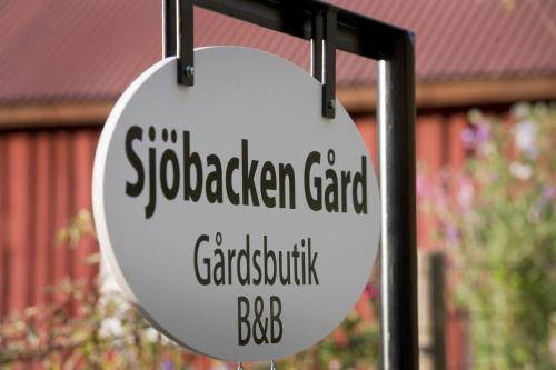 una señal para un centro ajardinado con un edificio en el fondo en Sjöbacken Gård, en Lerdala