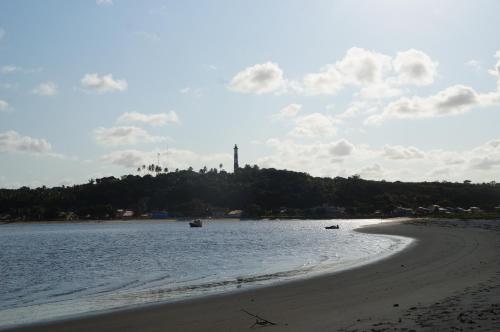 a beach with two boats in the water at Pe na Areia Boutique Hotel in Japaratinga