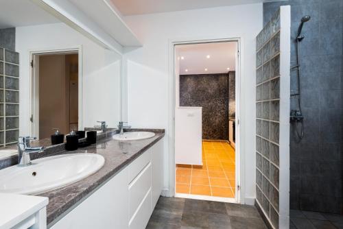 a bathroom with two sinks and a shower at Southern Dreams Apartments in Gennadi