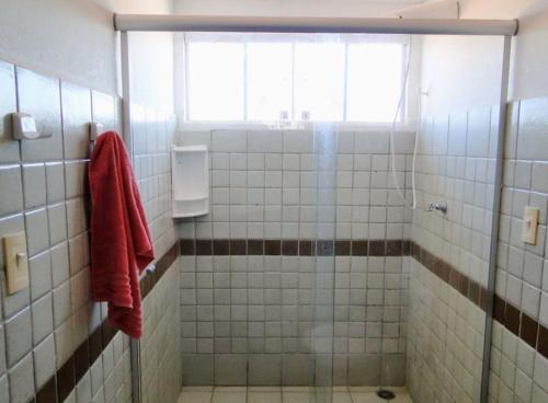 a bathroom with a shower with a red towel at Casa à beira-mar, piscina in Pitimbu
