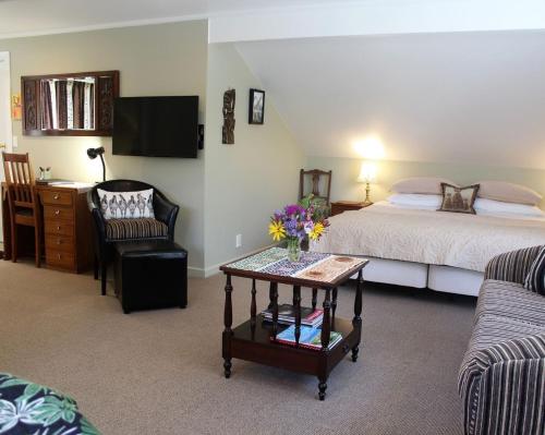 a bedroom with a bed and a table with flowers on it at Annick House Bed and Breakfast in Nelson