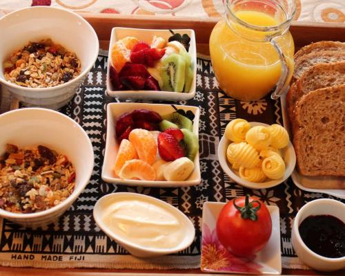 a bunch of bowls of food and a glass of orange juice at Annick House Bed and Breakfast in Nelson