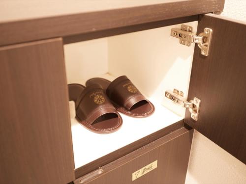 a pair of sandals are sitting in a drawer at Creass Hotel Tsubogawa Marche in Naha