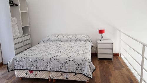 a small bedroom with a bed and a night stand at Lugones in Ezeiza