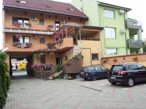 two cars parked in a parking lot in front of a building at Pensiunea Select in Arad