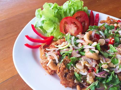a plate of food with a salad on a table at Lamphurai Riverside Resort and Spa in Trat