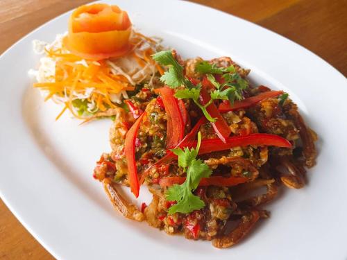 a white plate with food on a table at Lamphurai Riverside Resort and Spa in Trat