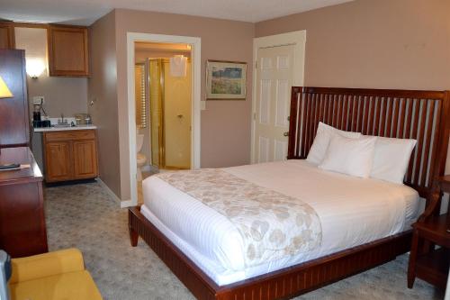 a bedroom with a bed and a kitchen at Cascades Inn in Bloomington