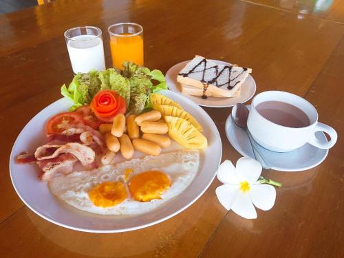 a plate of breakfast food with eggs and a cup of coffee at Lamphurai Riverside Resort and Spa in Trat