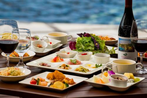 a table with plates of food and glasses of wine at Kanucha Bay Hotel & Villas in Nago