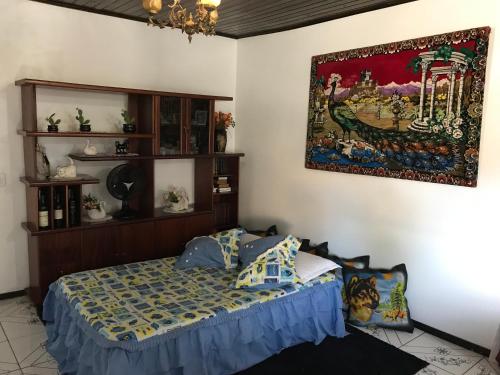 a bedroom with a bed and a painting on the wall at Casa Santana do Paraíso in Bonito