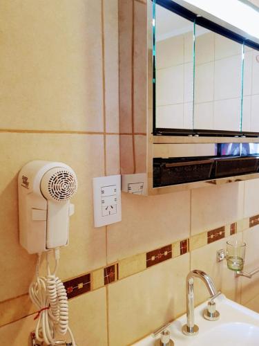 a bathroom with a blow dryer on the wall next to a sink at Raíces Federaenses Monoambientes in Federación