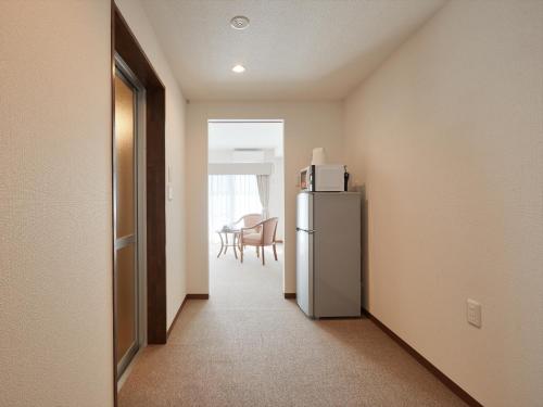 a hallway with a refrigerator and a dining room at Creass Hotel Tsubogawa Marche in Naha